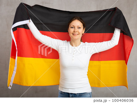 Adult cheerful woman holding Germany flag 100406036