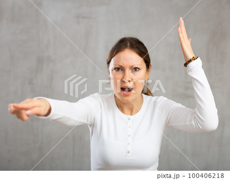 Woman argues while pointing accusingly with fury and anger Woman argues while pointing accusingly with fury and anger 100406218