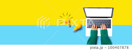 Person using a laptop computer and light bulbs Person using a laptop computer and light bulbs 100407878
