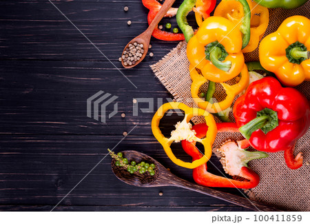 Three sweet peppers on a wooden background, Cooking vegetable salad Three sweet peppers on a wooden background, Cooking vegetable salad 100411859