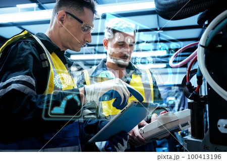Multiracial technicial engineer training with robot arm Multiracial technicial engineer training with robot arm 100413196