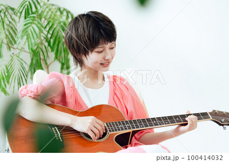 ギターを弾く若い女性 100414032