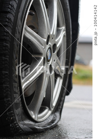パンクしたタイヤ、乗用車、普通車、旅行、アクシデント、事故 100414142
