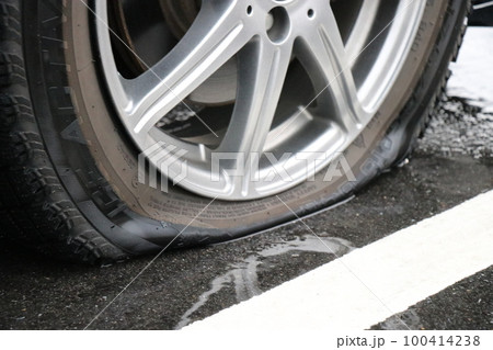 パンクしたタイヤ、乗用車、普通車、旅行、アクシデント、事故、雨の日 パンクしたタイヤ、乗用車、普通車、旅行、アクシデント、事故、雨の日 100414238