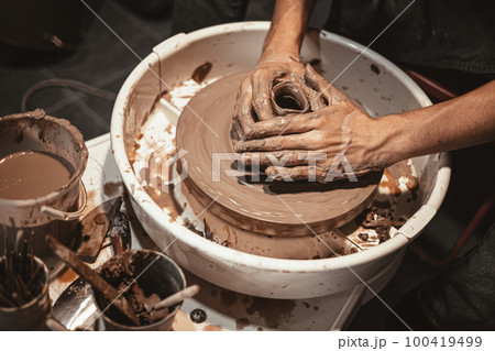 Master of pottery hancraft work modeling hand made clay on potter wheel in pottery workshop Master of pottery hancraft work modeling hand made clay on potter wheel in pottery workshop 100419499