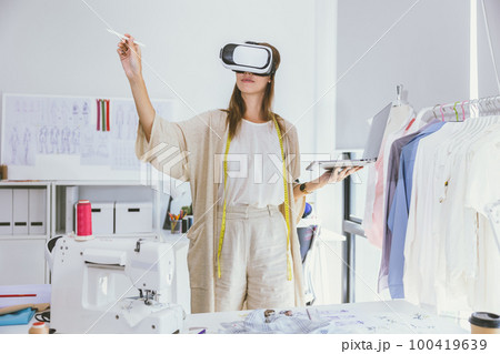 Costume designer using modern VR visual digital design technology in tailor studio Costume designer using modern VR visual digital design technology in tailor studio 100419639