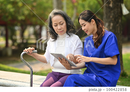 Female doctor in uniform instructing about treatment, giving consultation to elderly woman 100422858