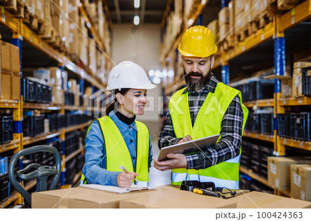 Warehouse workers checking stuff in warehouse with digital system in tablet, holding solar panel. Warehouse workers checking stuff in warehouse with digital system in tablet, holding solar panel. 100424363