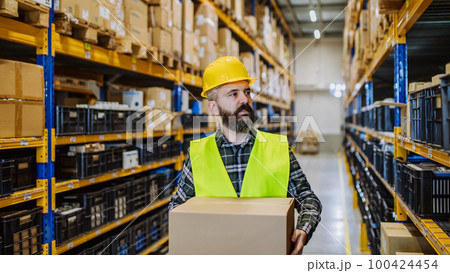 Warehouse worker stocking goods in a warehouse. 100424454