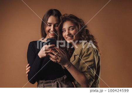 Portrait of two young happy girls, studio shoot, 100424599