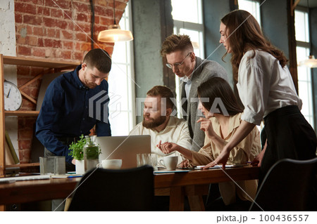 Young ambitious business people, employees at the meeting in office. Discussion of projects, checking documents 100436557