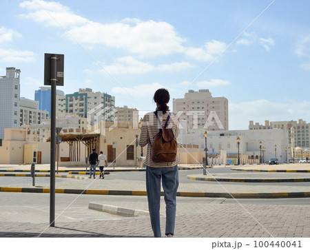 Woman tourist with a backpack on the Arab streets in the old part of Sharjah, UAE Woman tourist with a backpack on the Arab streets in the old part of Sharjah, UAE 100440041