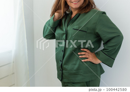 Close up female in cozy pajamas at home - wellbeing and comfort morning concept Close up female in cozy pajamas at home - wellbeing and comfort morning concept 100442580