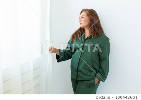 Cute female model in pajama enjoying morning. Pleasant woman copy space. Good mood Cute female model in pajama enjoying morning. Pleasant woman copy space. Good mood 100442601