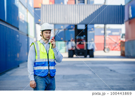 Foreman using radio walkie talkie control loading containers box in cargo for import export 100443869