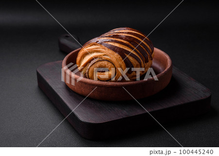 Delicious sweet crispy fresh baked cinnamon bun Delicious sweet crispy fresh baked cinnamon bun 100445240