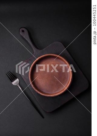 Empty brown colored ceramic plate on dark concrete background 100445251