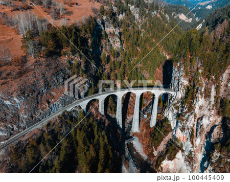 Aerial view famous mountain in Filisur, Switzerland. Landwasser Viaduct - world heritage with train Glacier express in Swiss Alps. 100445409