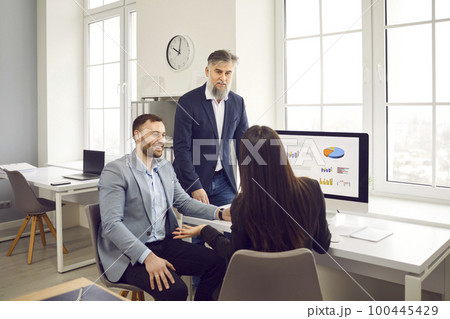 Business team having a work meeting, discussing their strategy, and using a computer Business team having a work meeting, discussing their strategy, and using a computer 100445429