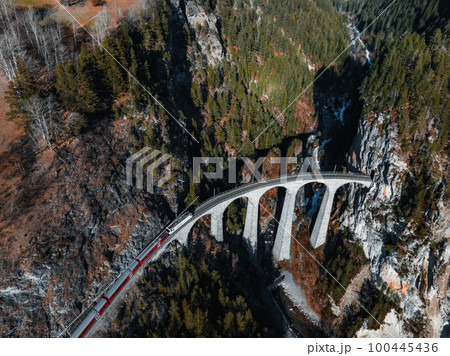 Aerial view of Train passing through famous mountain in Filisur, Switzerland. Landwasser Viaduct world heritage with train Glacier express in Swiss Alps. 100445436