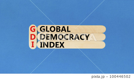 GDI global democracy index symbol. Concept words GDI global democracy index on wooden stick on a beautiful blue table blue background. Business and GDI global democracy index concept. Copy space. 100446502