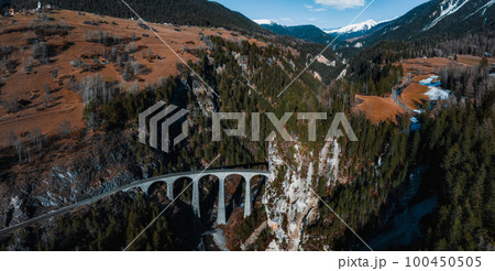 Aerial view famous mountain in Filisur, Switzerland. Landwasser Viaduct - world heritage with train Glacier express in Swiss Alps. 100450505