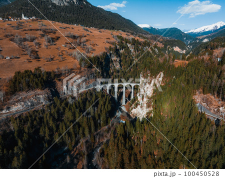 Aerial view famous mountain in Filisur, Switzerland. Landwasser Viaduct - world heritage with train Glacier express in Swiss Alps. 100450528