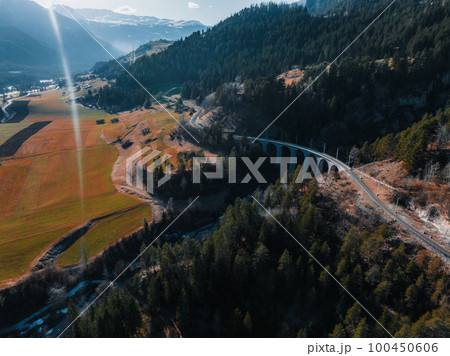 Aerial view of Train passing through famous mountain in Filisur, Switzerland. Landwasser Viaduct world heritage with train Glacier express in Swiss Alps. 100450606