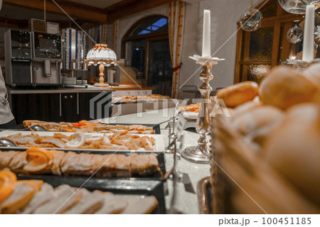 Various meat dishes arranged in trays at counter inside luxury alpine hotel during buffet dinner 100451185