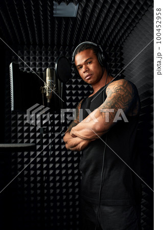 African American at the recording studio in headphones reads rap African American at the recording studio in headphones reads rap 100452958