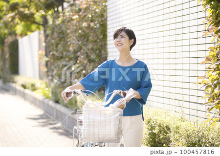 自転車で買い物に行く若い女性 自転車で買い物に行く若い女性 100457816