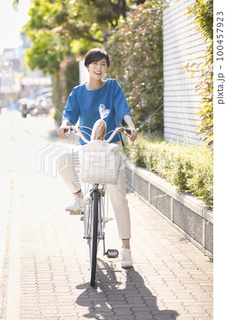 自転車で買いに行く若い女性 自転車で買いに行く若い女性 100457923