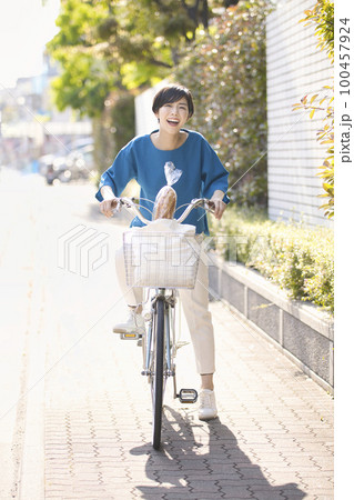 自転車で買いに行く若い女性 100457924