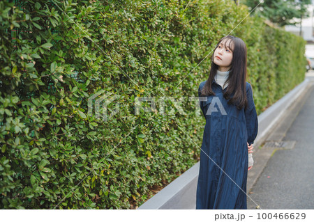 緑の植木の前を歩く女の子 緑の植木の前を歩く女の子 100466629