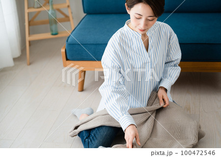洗濯物を畳む若い女性 ライフスタイルイメージ 洗濯物を畳む若い女性 ライフスタイルイメージ 100472546