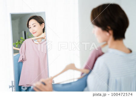 鏡の前で服選びをしている若い女性 ファッションイメージ 鏡の前で服選びをしている若い女性 ファッションイメージ 100472574