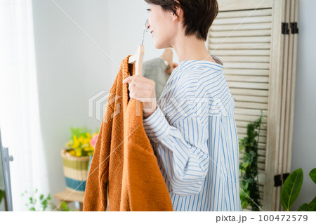 鏡の前で服選びをしている若い女性 ファッションイメージ 鏡の前で服選びをしている若い女性 ファッションイメージ 100472579