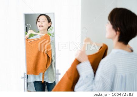 鏡の前で服選びをしている若い女性 ファッションイメージ 鏡の前で服選びをしている若い女性 ファッションイメージ 100472582