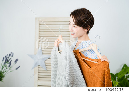 鏡の前で服選びをしている若い女性 ファッションイメージ 鏡の前で服選びをしている若い女性 ファッションイメージ 100472584