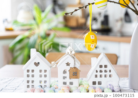Key to house of cozy home with Easter decor with rabbit and eggs on table of kitchen. Building, design, project, moving to new house, mortgage, insurance, rent and purchase real estate Key to house of cozy home with Easter decor with rabbit and eggs on table of kitchen. Building, design, project, moving to new house, mortgage, insurance, rent and purchase real estate 100473115