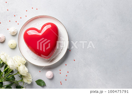 frame made of rose flowers, heart shape mousse cake and sweets 100475791