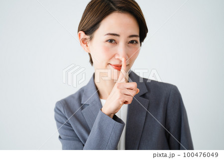 口に指を当てる若い女性　ビジネスイメージ	 100476049