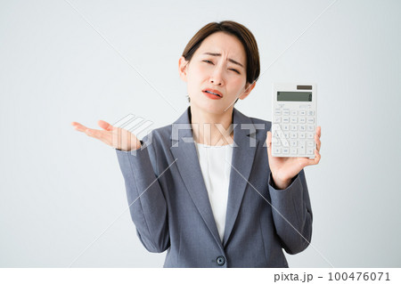 電卓を持って肩をすくめる若い女性　ビジネスイメージ 100476071