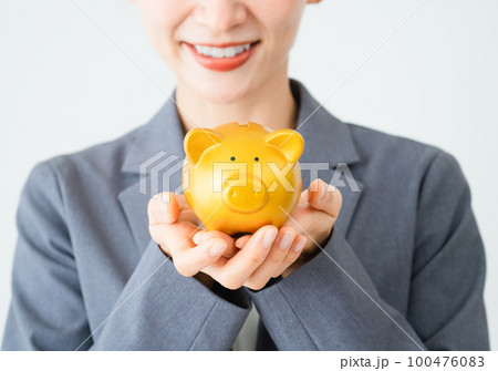 豚の貯金箱を持っている若い女性 ビジネスイメージ 豚の貯金箱を持っている若い女性 ビジネスイメージ 100476083