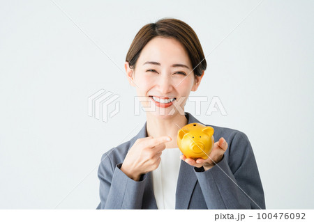 豚の貯金箱を持っている若い女性　ビジネスイメージ 100476092