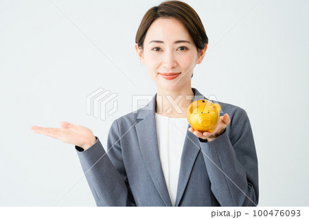 豚の貯金箱を持っている若い女性 ビジネスイメージ 豚の貯金箱を持っている若い女性 ビジネスイメージ 100476093