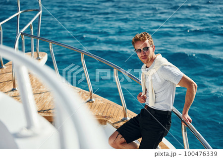 Posing for a camera. Young male tourist is on the yacht on the sea. Conception of vacation 100476339