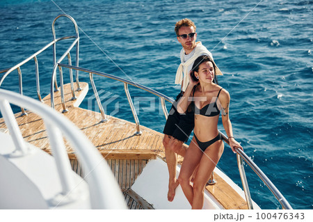 Cheerful young couple standing on the yacht on the sea. Conception of vacation Cheerful young couple standing on the yacht on the sea. Conception of vacation 100476343
