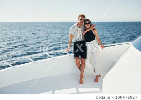 Cheerful young couple standing on the yacht on the sea. Conception of vacation Cheerful young couple standing on the yacht on the sea. Conception of vacation 100476927