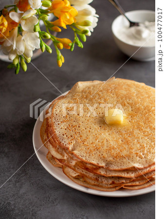 stack of hot crepes pancakes with butter 100477017